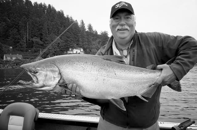 Terry Mulkey holding large salmon on boat